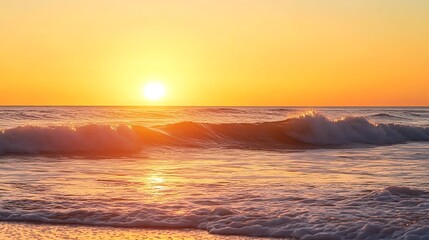 Obraz premium Golden sunset over ocean waves creating a serene atmosphere with vibrant colors and gentle reflections on the water