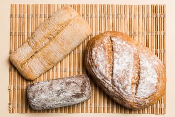 Assortment of freshly baked bread with napkin on rustic table top view. Healthy unleavened bread. French bread