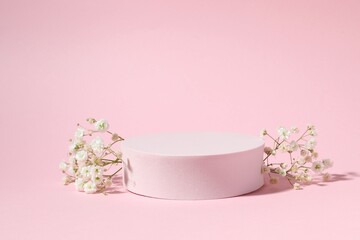 Podium and white gypsophila flowers on a colored background