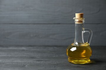 
Bottle of fresh olive oil and olives with leaves on wooden background
