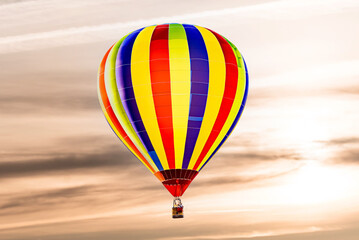 Colorful hot air balloon flying under sunset sky