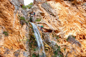 Beautiful Waterfall Cascading Down Rocky Cliffs Surrounded by Lush Vegetation in a Serene Landscape
