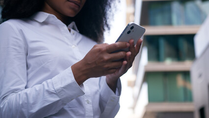 Close up unrecognizable African American woman user typing mobile phone smartphone cellphone online businesswoman cyberspace crypto banking freelancer trading business girl female e-commerce work city
