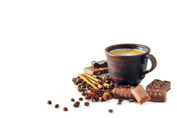 Cup of cappuccino, coffee beans, pieces of chocolate, cinnamon and star anise.
