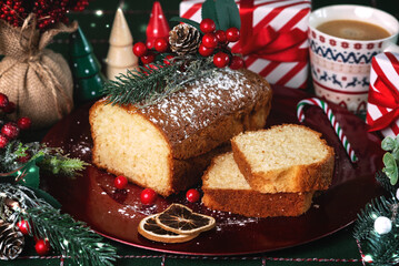 Homemade christmas cake on a red plate with christmas coffee cup and christmas decor ornaments. Christmas festive pastry dessert concept