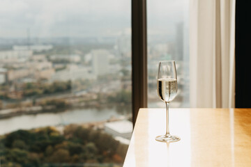 A glass of champagne against the backdrop of a panoramic window.