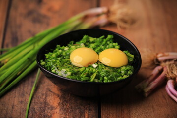 bowl of egg yolks isolated on white background, top view with green vegetables.close up image of two eggs yolk in a bowl are one of the food ingredients on the restaurant table in the kitchen .
