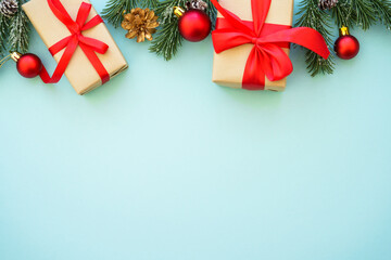 Christmas presents and decorations with fir tree at blue background. Flat lay image with copy space.