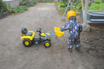a child boy on a wheeled bulldozer tractor electrical work bulbs and light, photo without filters
