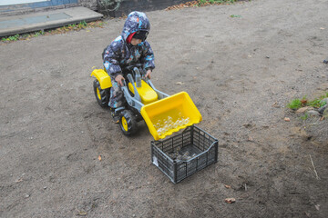 a child boy on a wheeled bulldozer tractor electrical work bulbs and light, photo without filters