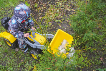 a child boy on a wheeled bulldozer tractor removes snow with a snow plow, photo without filters