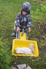 a child boy on a wheeled bulldozer tractor removes snow with a snow plow, photo without filters