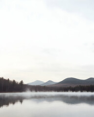 Fototapeta premium A tranquil lake with a misty morning landscape.
