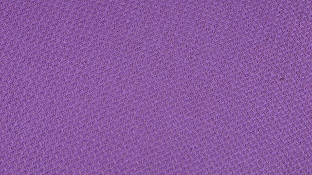 Relief, textured textile background made of purple cotton of cadbury shade fabric on a rotating display case. Sewing, fashion and clothing design. Top view.