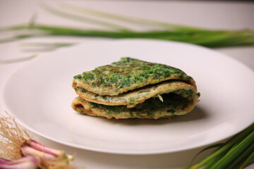 Stuffed omelette with tomatoes and spinach on white plate.Herb omelette with chives and oregano sprinkled with chili flakes, garlic panini toasts.Omelette with salad and tomatoes on plate
