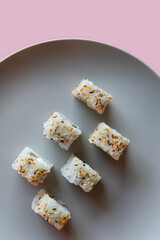 Japanese sushi on a gray plate on a pink background. Japanese food culture.