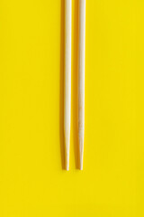 wooden sushi chopsticks on yellow background