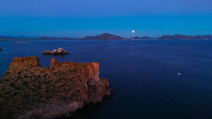 Early hours of a full moon night in the sea of San Carlos Sonora. The rocky cliffs full of desert...