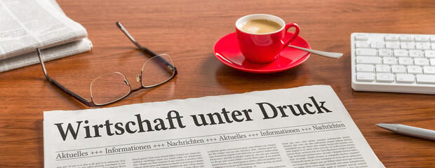 Zeitung auf Schreibtisch - Wirtschaft unter Druck
