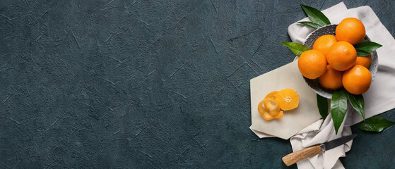 Basket with fresh juicy oranges on black background