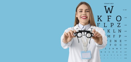 Female ophthalmologist with trial frame and eye test chart on light blue background with space for text