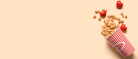 Bucket of popcorn and hearts on yellow background. Valentine's Day celebration