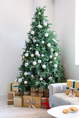 Interior of festive living room with gift boxes under Christmas tree