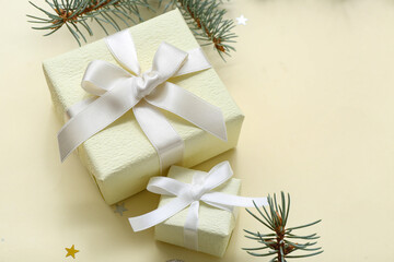 Christmas tree branches and gift boxes on yellow background