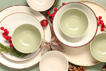 Beautiful table setting with Christmas tree branches and decorations on green background