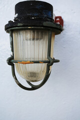 Old rusty metal lamp at old ship deck at sea