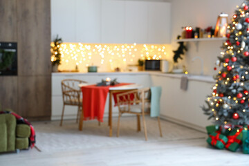 Blurred view of kitchen with counters, dining table and Christmas lights