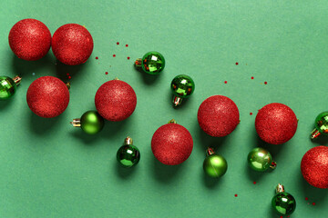Composition with different Christmas balls and confetti on green background