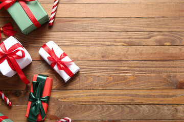 Fototapeta premium Christmas gift boxes and candy canes on wooden background