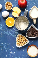 Different ingredients for preparing Christmas pie on blue background