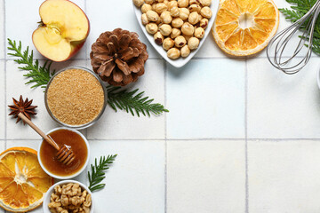 Beautiful composition with different ingredients for preparing Christmas pie on white tile background