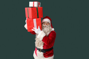 Santa Claus with Christmas gifts on green background