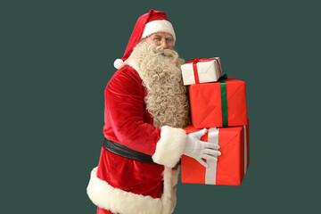 Santa Claus with Christmas gifts on green background