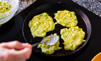 Cooking delicious zucchini pancakes in a frying pan
