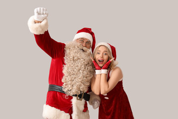 Happy Santa Claus with beautiful woman on white background