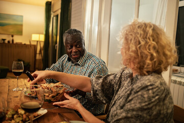 Senior couple enjoying dinner and conversation at home with wine
