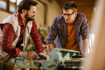 Carpenters working together on a project in their woodworking workshop