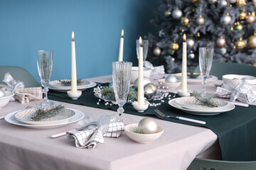 Beautiful table setting with burning candles and Christmas decorations in dining room, closeup