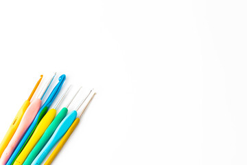 Various size bright crochet hooks isolated on white background. Colorful crochet hooks. Copy space