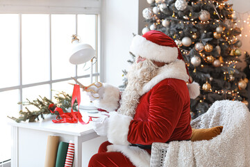 Santa Claus making Christmas gift at home