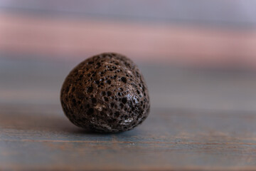 Photograph of a round, black stone found on the beach