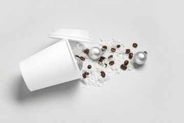 Cup with coffee beans, snow and Christmas balls on light background