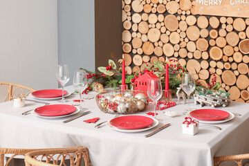 Table served for Christmas dinner near wooden wall