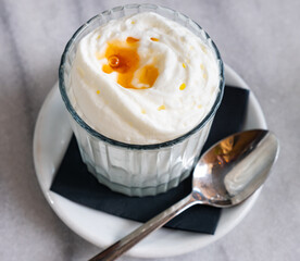 Low-calorie dessert made of yogurt mousse, decorated with liquid transparent honey. Homemade dish, diet menu, ideas of simple desserts for home cooking.