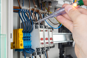 Hand Using Voltage Tester on Electrical Connections