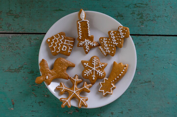 Painted traditional Christmas gingerbreads arranged on old vintage painted table in daylight,...
